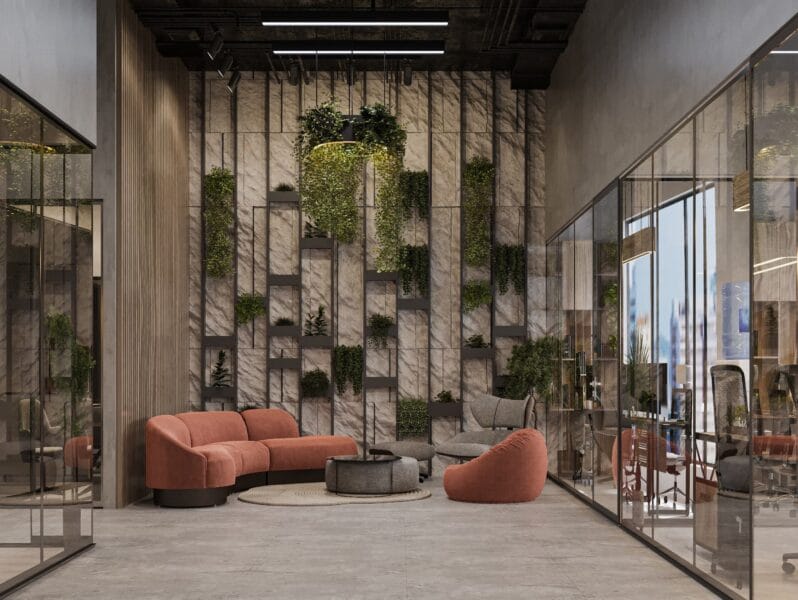 Un espace détente contemporain avec un canapé en velours terracotta, un fauteuil lounge et un mur végétalisé design. Le tout est entouré de bureaux vitrés dans un intérieur industriel chic.